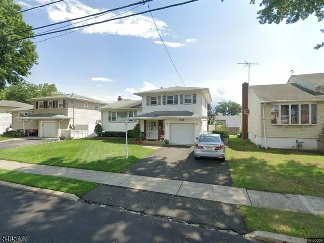 a front view of a house with a garden and plants