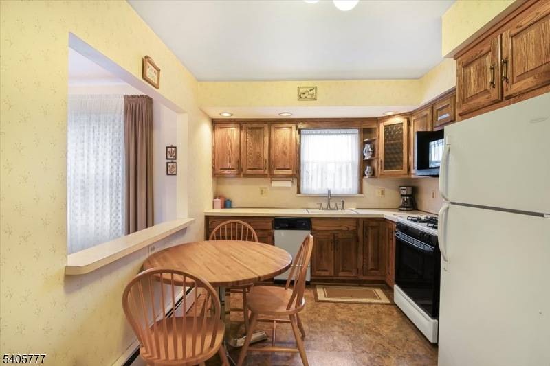 735 Garden Street Union, NJ 07083 - Photo 11 of 29 a kitchen with stainless steel appliances granite countertop a sink a stove a refrigerator with a dining table and chairs