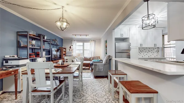 a very nice looking dining room with kitchen island stainless steel appliances a table and chairs