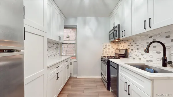 a kitchen with granite countertop a sink stove and refrigerator