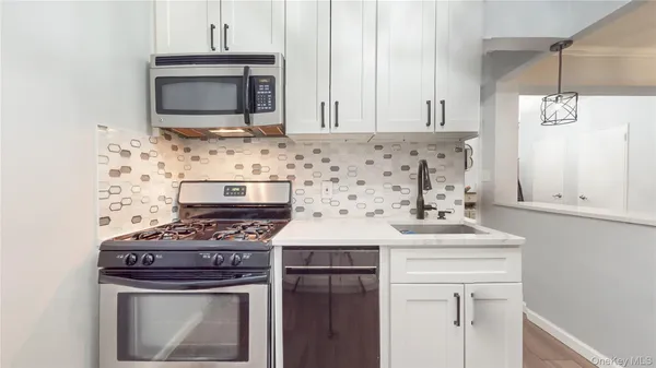 a kitchen with granite countertop a stove and a microwave