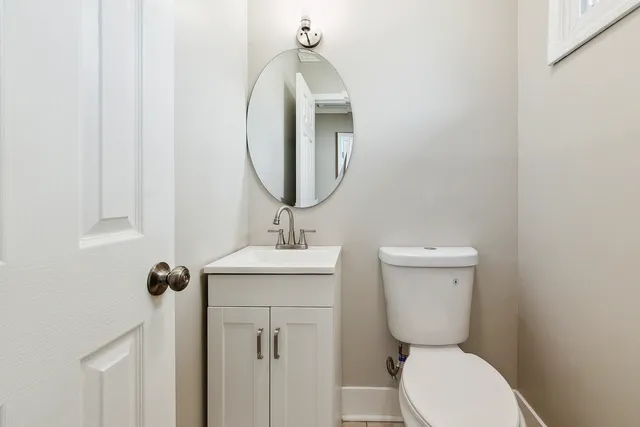 a bathroom with a toilet a sink and mirror
