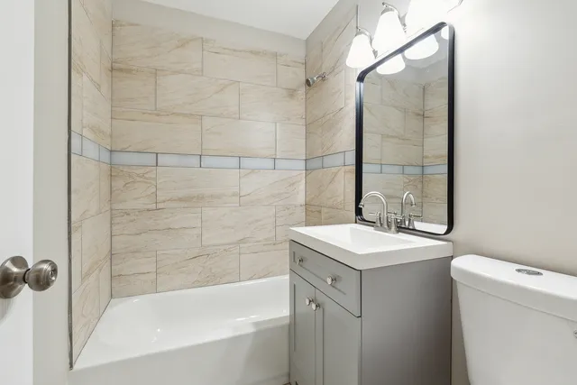 a bathroom with a sink toilet vanity and shower