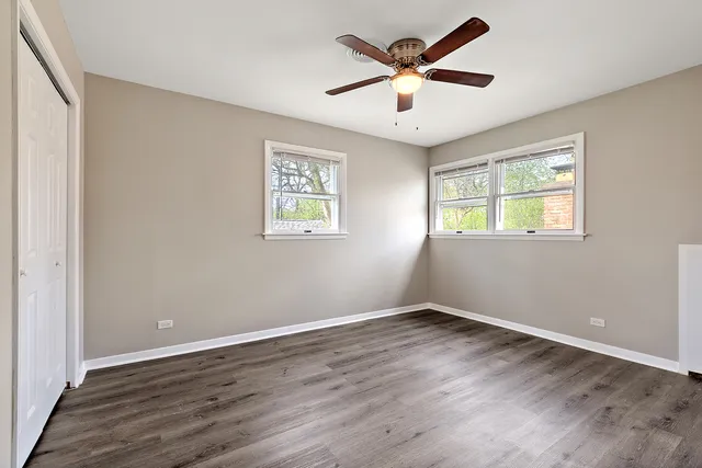 a view of a big room with wooden floor and windows