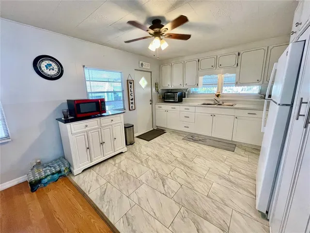 a kitchen with granite countertop a sink a stove top oven and cabinets