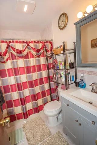 a bathroom with a sink toilet vanity and shower