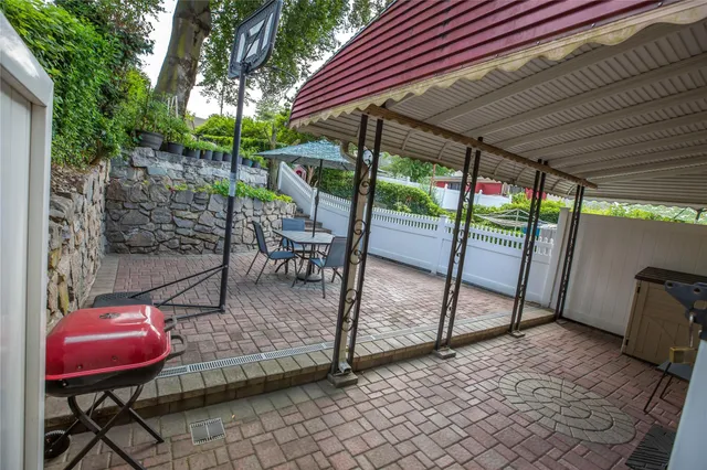 a view of a backyard with table and chairs under an umbrella