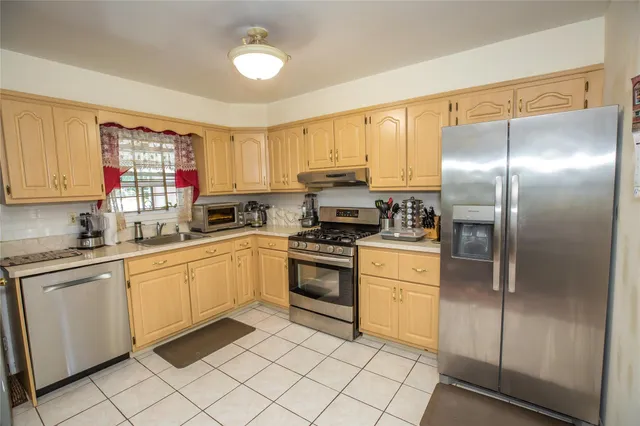 a kitchen with a refrigerator sink and cabinets