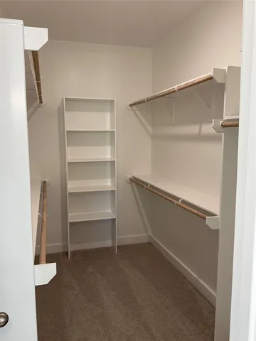 an empty room with wooden floor closet and windows