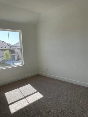 an empty room with closet and windows