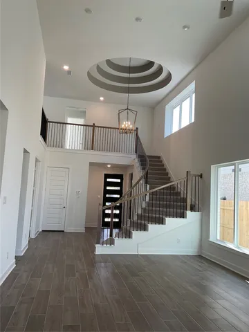 a view of staircase with railing and white walls