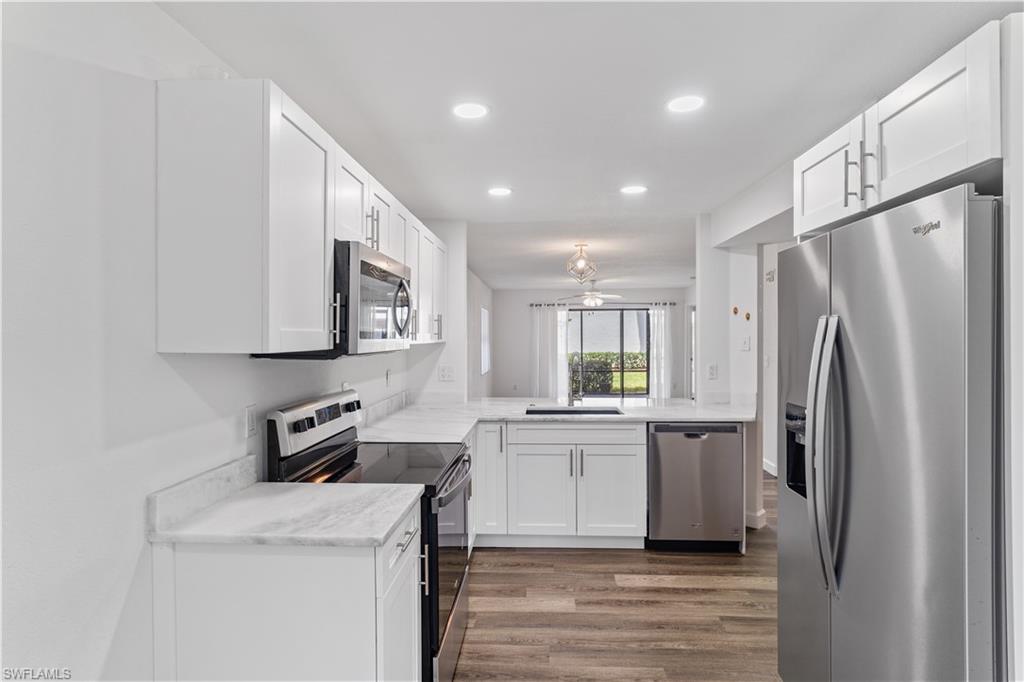 4951 Pepper Circle, Unit A101 Naples, FL 34113 - Photo 13 of 13 a kitchen with stainless steel appliances a refrigerator stove and sink