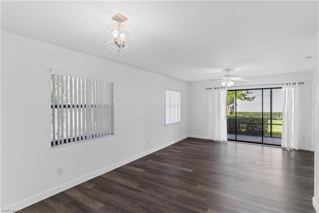 4951 Pepper Circle, Unit A101 Naples, FL 34113 - Photo 2 of 13 wooden floor in an empty room with a window