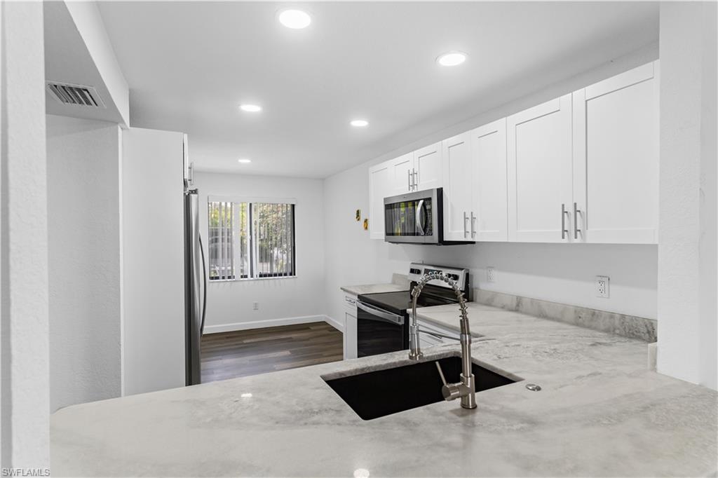 4951 Pepper Circle, Unit A101 Naples, FL 34113 - Photo 3 of 13 a view of a livingroom with kitchen island furniture and a window