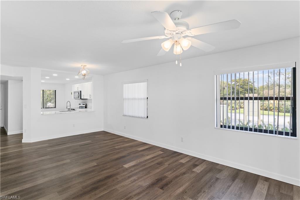 4951 Pepper Circle, Unit A101 Naples, FL 34113 - Photo 5 of 13 a view of an empty room with wooden floor and a window