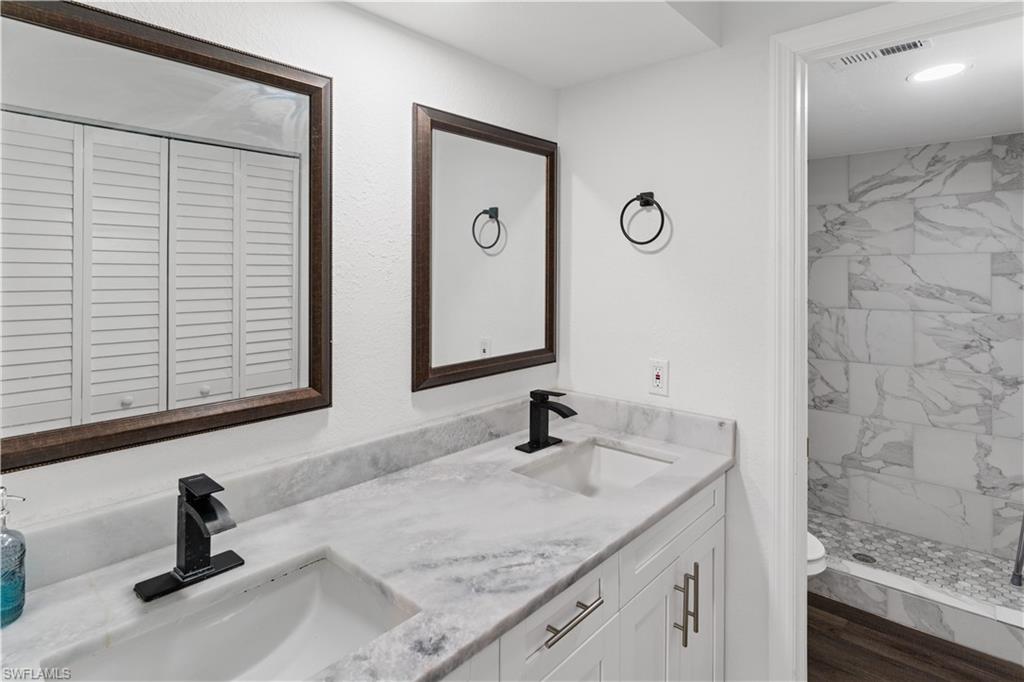 4951 Pepper Circle, Unit A101 Naples, FL 34113 - Photo 7 of 13 a bathroom with a sink and a mirror