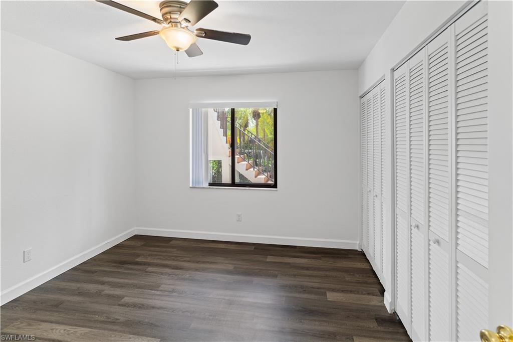 4951 Pepper Circle, Unit A101 Naples, FL 34113 - Photo 8 of 13 wooden floor in an empty room with a window