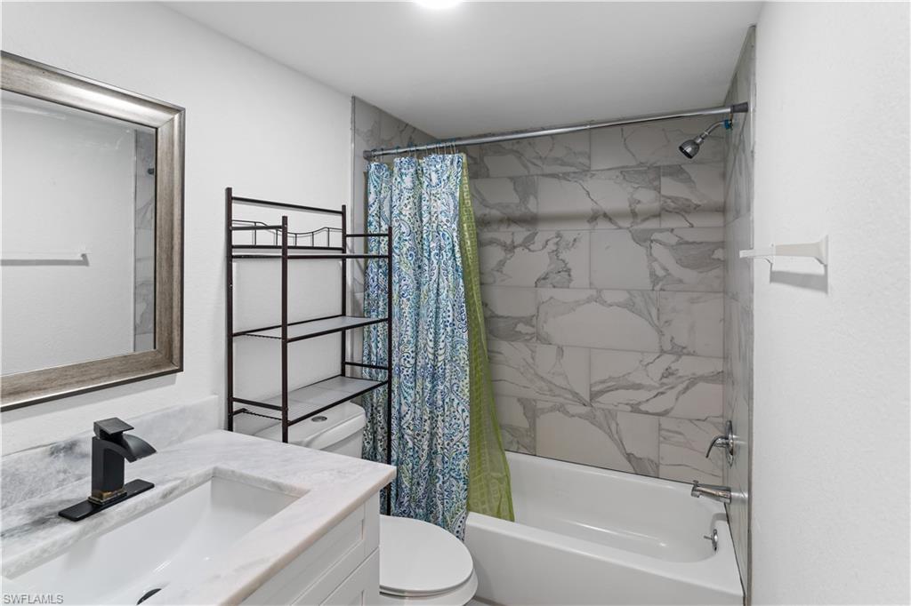 4951 Pepper Circle, Unit A101 Naples, FL 34113 - Photo 9 of 13 a bathroom with a sink toilet and shower