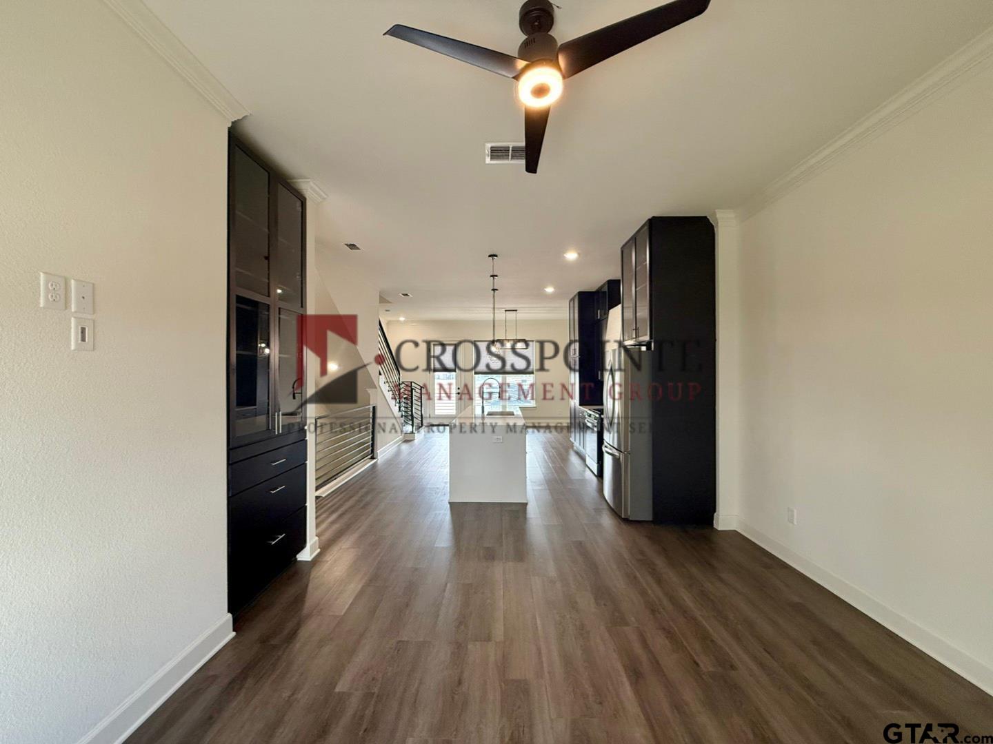 548 West Erwin Street Tyler, TX 75702 - Photo 8 of 27 a view of a hallway with wooden floor and a kitchen