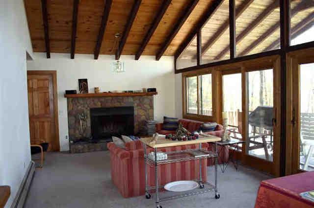 417 Fred Snow Road Becket, MA 01223 - Photo 3 of 10 a living room with furniture a fireplace and a floor to ceiling window