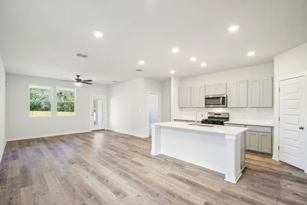 a kitchen with stainless steel appliances a white stove top oven sink and cabinets