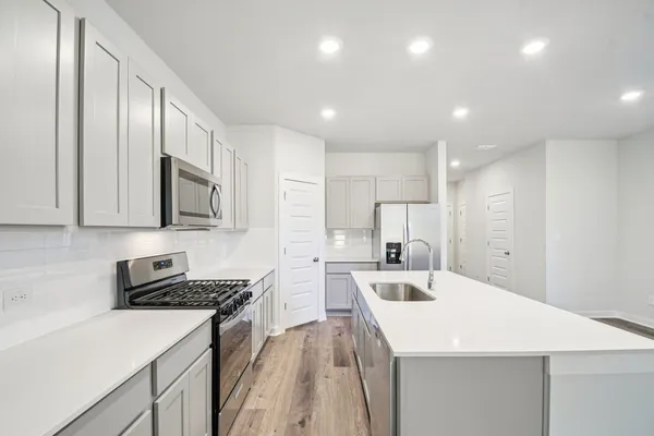 a kitchen with stainless steel appliances a refrigerator sink and microwave