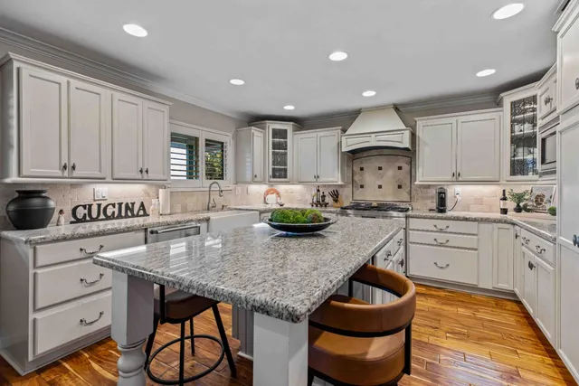 a kitchen with granite countertop kitchen island stainless steel appliances a stove a sink and a center island