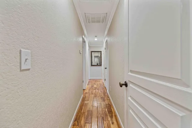 a view of a hallway with wooden floor and staircase