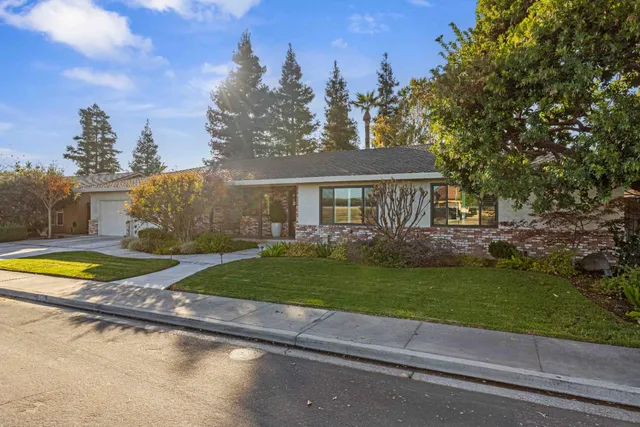 a view of a house with a swimming pool and a yard