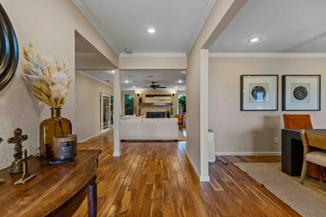 a view of a hallway with wooden floor and furniture
