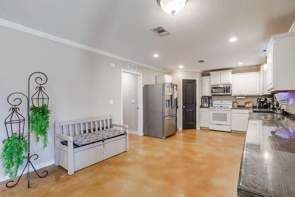 a kitchen with granite countertop a refrigerator and a stove top oven