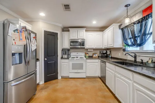 a kitchen with granite countertop a refrigerator stove and sink