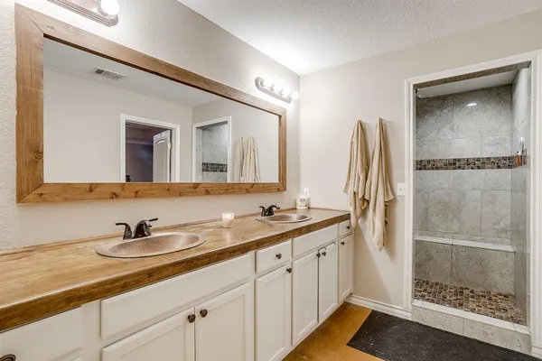 a bathroom with a double vanity sink and mirror
