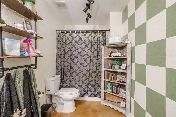 a bathroom with a toilet and a shower curtain
