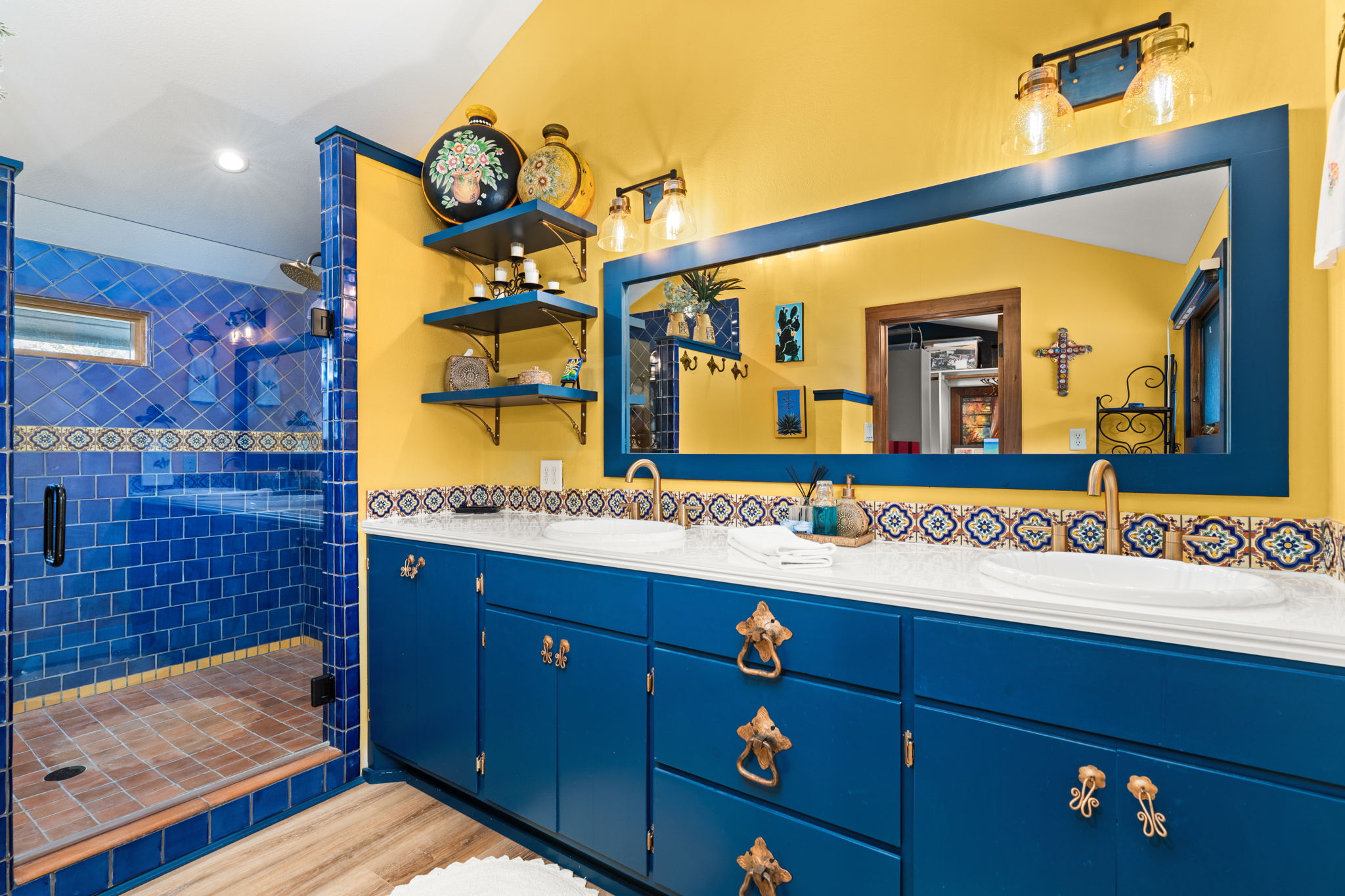 11941 Overlook Pass Austin, TX 78738 - Photo 22 of 40 Bathroom for loft, featuring a dual vanity with a white countertop and blue cabinetry, a large framed mirror, and a walk-in shower with blue tiled walls and a glass enclosure