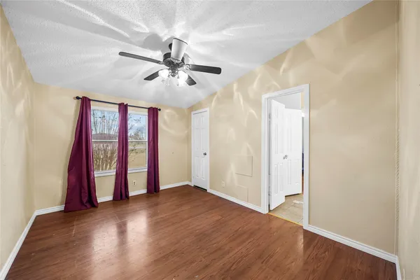 a living room with furniture kitchen view and a wooden floor