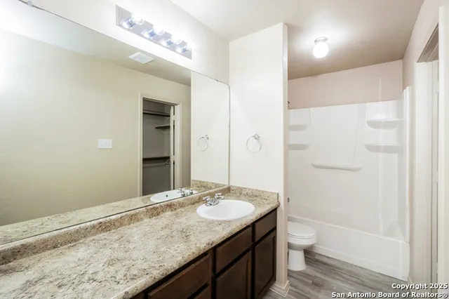 a bathroom with a granite countertop sink toilet and shower
