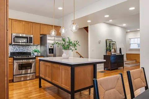 a kitchen with stainless steel appliances kitchen island granite countertop a stove a sink and a refrigerator
