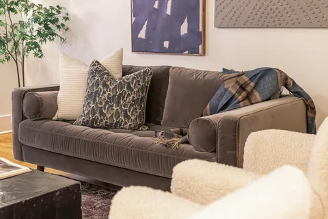 a living room with furniture and a potted plant