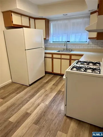 a kitchen with a stove a refrigerator and a sink