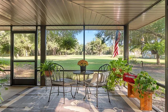 a view of a porch with chairs and backyard