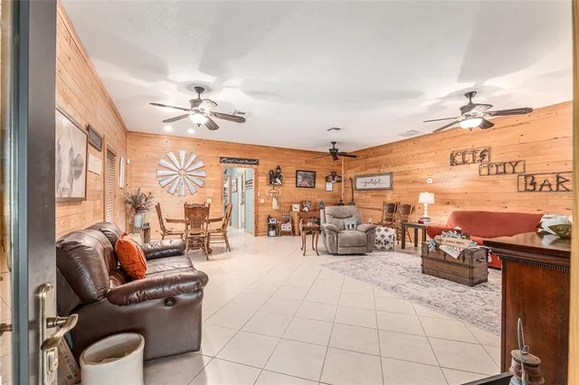 a living room with furniture a chandelier and a dining table