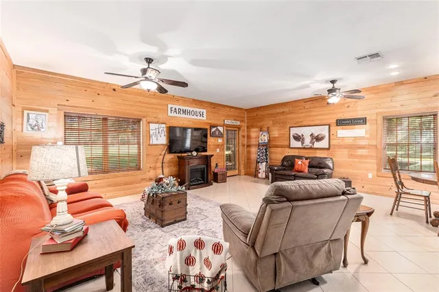 a living room with furniture a flat screen tv and a large window