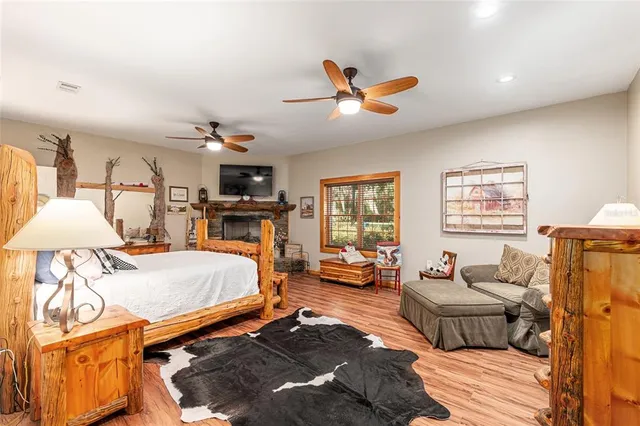a bedroom with a bed a flat screen tv and a fireplace