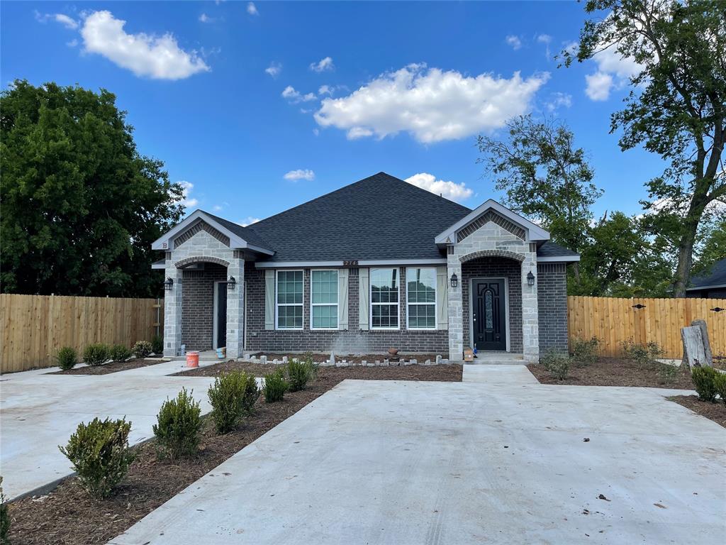 a front view of a house with a yard and potted plants