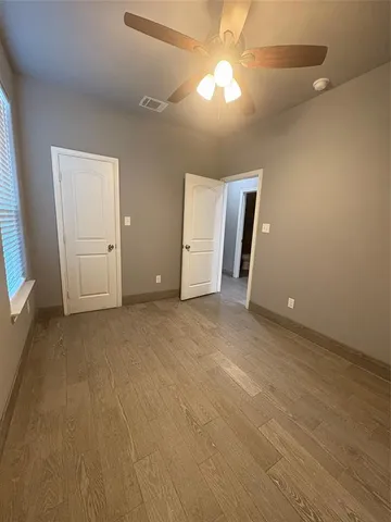 an empty room with closet and windows