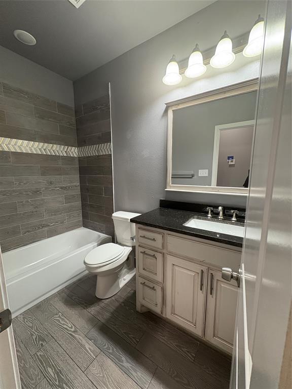 216 Cleveland Street, Unit B Cleburne, TX 76031 - Photo 14 of 26 a bathroom with a sink a toilet a mirror and bathtub