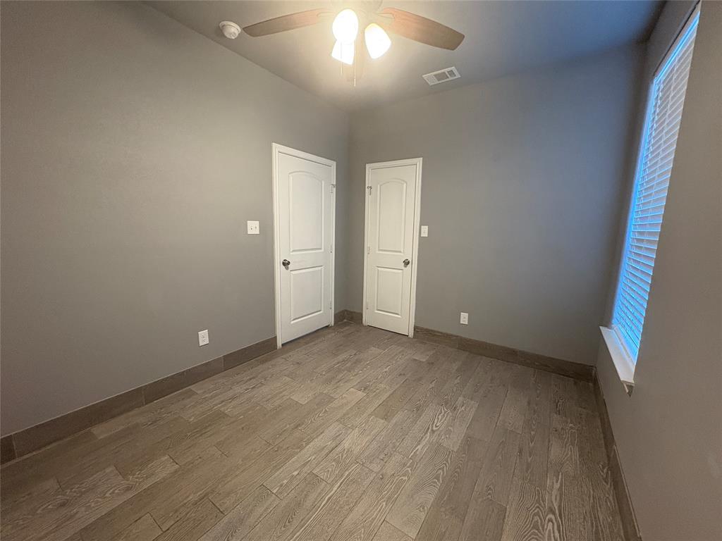 216 Cleveland Street, Unit B Cleburne, TX 76031 - Photo 16 of 26 an empty room with wooden floor and windows