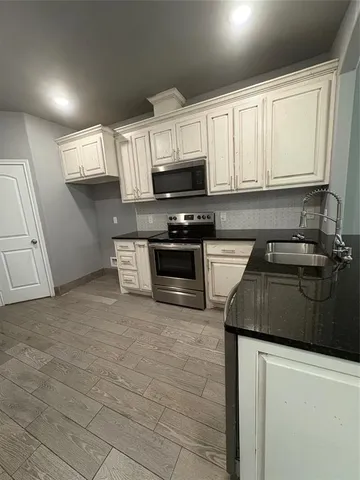 a kitchen with stainless steel appliances granite countertop a sink a stove a microwave and cabinets