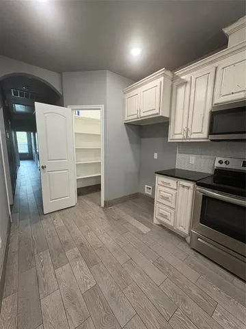 a kitchen with a refrigerator stove and white cabinets